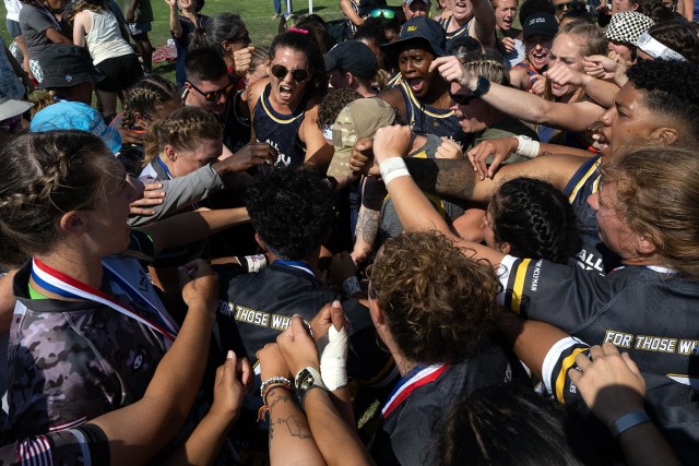 Wearing a pink ribbon in her hair, Navy Ensign Megan Neyen leads a huddle of rugby players from all services in a cheer "For Those Who Can’t" at the conclusion of the 2024 Armed Forces Women’s Rugby Championships in San Diego, Calif....