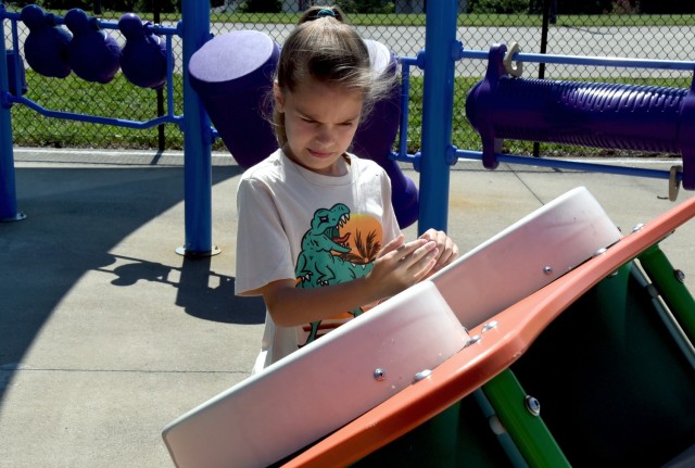 Jade Smith, 10, daughter of Sgt. 1st. Class Kyle Smith, Recruiting and Retention College instructor,  plays on an interactive game at the new inclusive playground on Fort Knox, Kentucky, July 18 (U.S. Army photo by Shannon Collins)