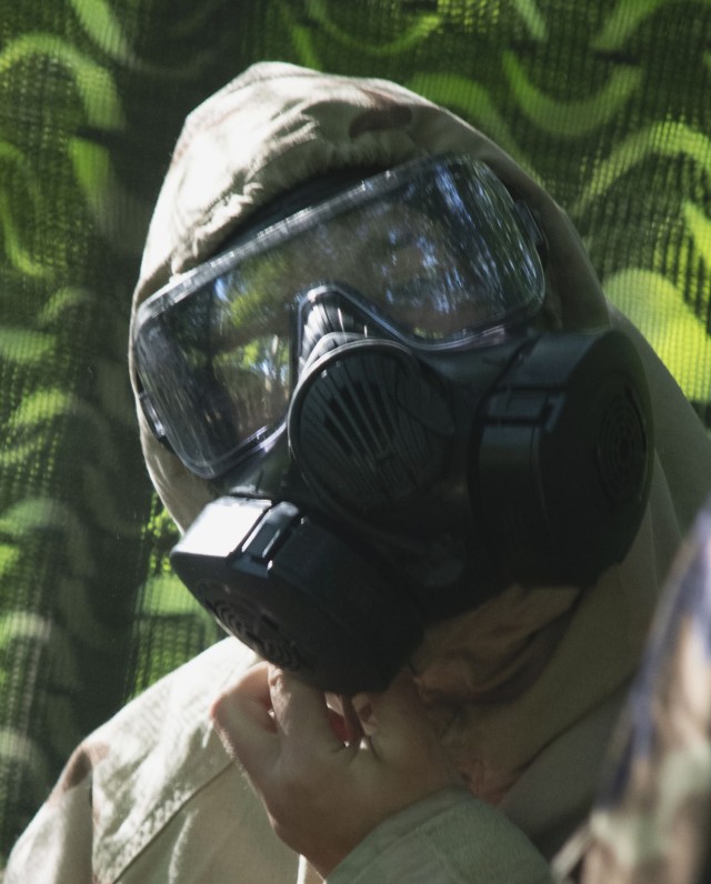 Cadet Rebecca Karis secures her M50 protective mask as she dons her Mission Oriented Protective Posture gear during chemical, biological, radiological, nuclear training at Cadet Summer Training Advanced Camp on Fort Knox in Kentucky, July 19, 2024...