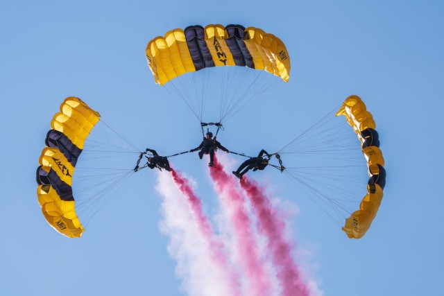 Sgt. 1st Class Rafael Torres, Sgt. 1st Class Zach Krietenstein, and Sgt. 1st Class Griffin Mueller of the U.S. Army Parachute Team fly in an advanced canopy maneuver for a parachute jump at Arctic Thunder on 19 July 2024.  The parachute...