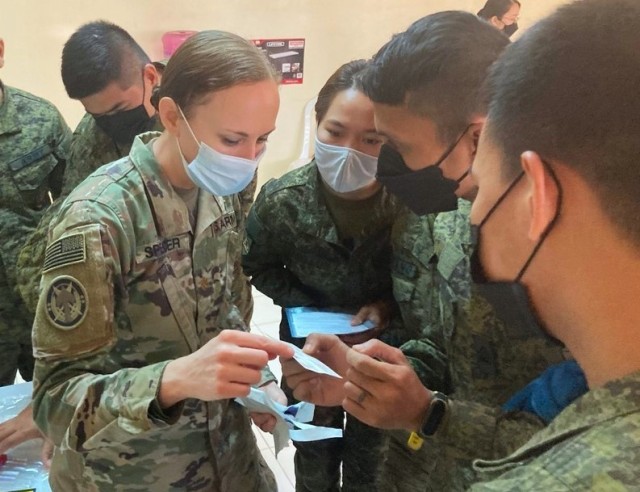 Maj. Kelly Spencer, 5th Security Force Assistance Brigade Nurse and Medical Advisor, discusses the use of Eldon blood-typing cards with medics and nurses from the Philippine Army. The hands-on training was part of a class on fresh whole blood...