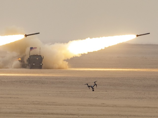 The American flag atop a High Mobility Artillery Rocket Systems bows as the HIMARS fires during a combined fire mission during exercise Al Tahreer. The HIMARs, part of Task Force Spartan, was part of a combined fire mission with the Kuwait Land...