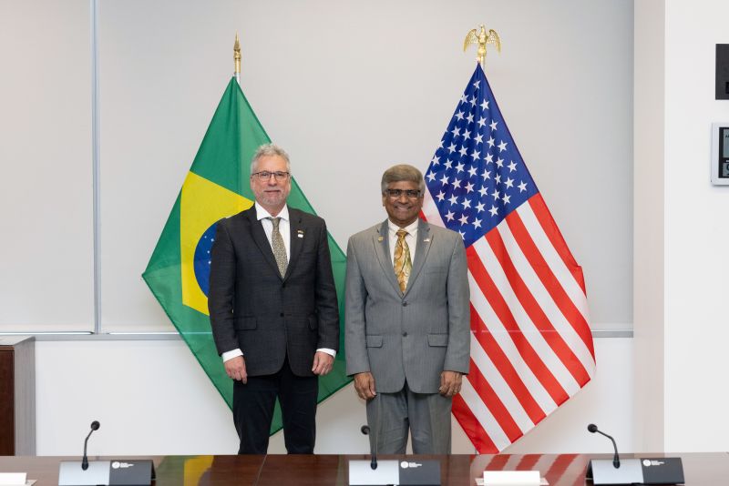 two men standing in front of their nations flag