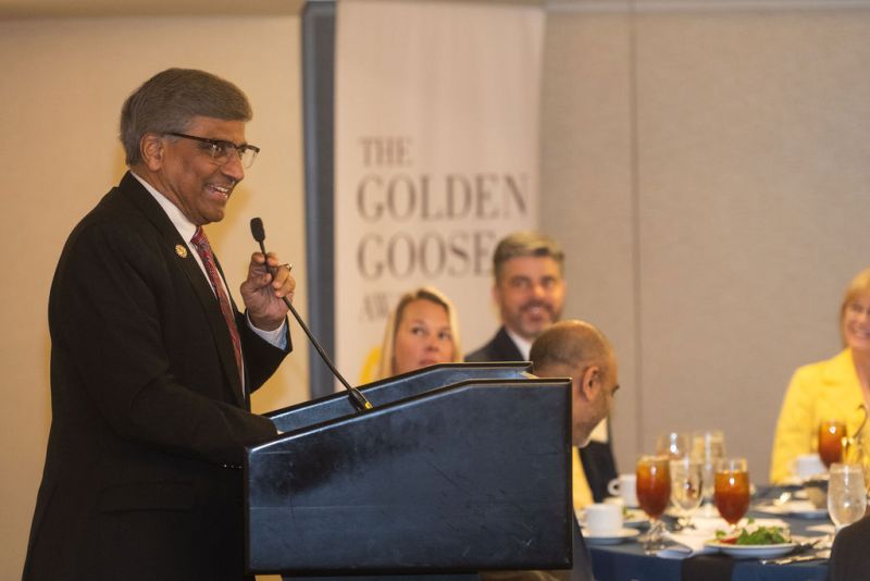 man speaking into a microphone at a podium