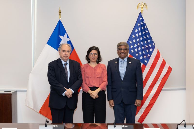 group of 3 people standing in front of flags