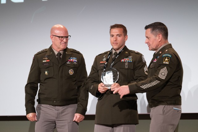 Army Vice Chief of Staff Gen. James J. Mingus and Sgt. Maj. of the Army Michael R. Weimer present the Noncommissioned Officer of the Year Award to Sgt. 1st Class Alexander Haynes at the Association of the U.S. Army Annual Meeting and Exposition in...