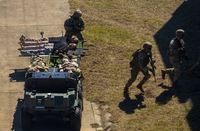 Soldiers of the Maneuver Center of Excellence Experimental Company, 1st Battalion, 29 Infantry Regiment, 316th Cavalry Brigade, employ integrated robotics during a simulated operation as attendees of the Human Machine Integration Summit II view...