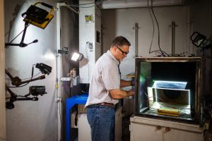 Sandia National Laboratories' Genaro Quintana prepares a battery for testing in a vault at the Battery Abuse Testing Lab. Sandia’s research on detecting battery failures sooner in electric vehicles was published in the Journal of the Electrochemical Society. (Photo by Craig Fritz) Click on thumbnail for a high-resolution image. 