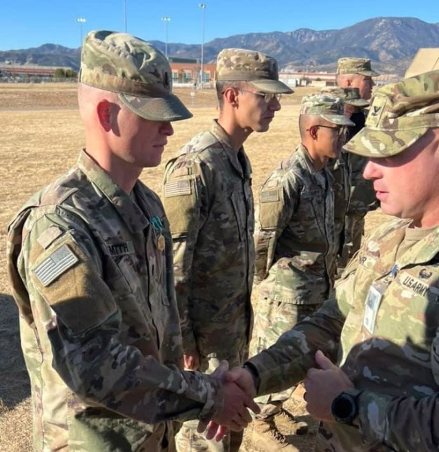 Col. Andy Kiser, right, commander of 2nd Stryker Brigade Combat Team, 4th Infantry Division, Fort Carson, Colorado, congratulates Capt. Kyle Smith, a logistics officer with 4th ID, for receiving an Army Commendation after a National Training...