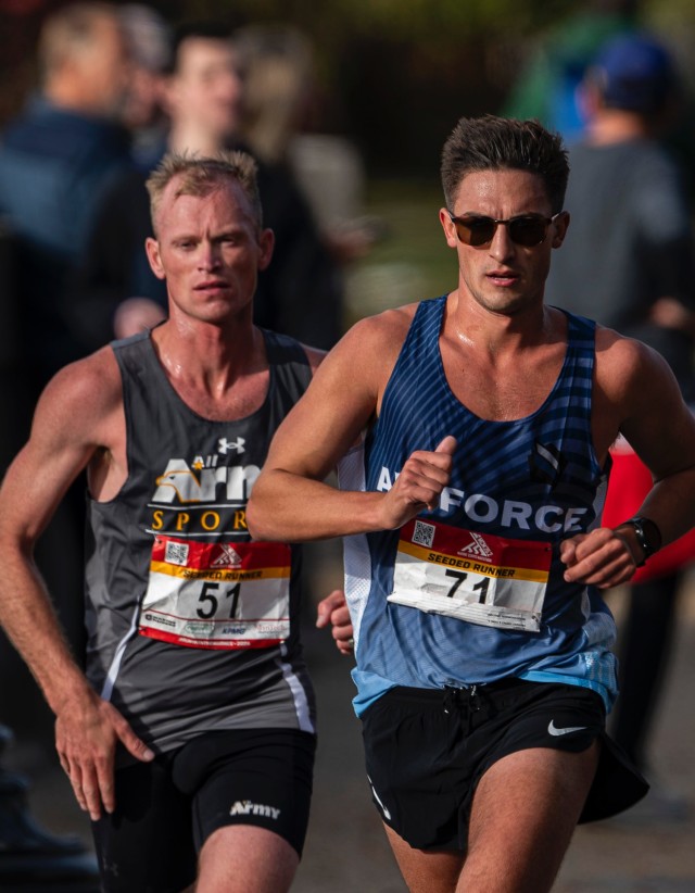 Army Capt. Kyle Smith, from Linden, Michigan, and Air Force Capt. George Henry Crist, from Sacramento, California, pace in a pack at mile marker 16 during the 2024 Marine Corps Marathon, held in conjunction with the 2024 Armed Forces Marathon...