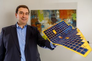 Murat Okanden, CTO and founder of mPower Technology Inc., demonstrates the flexibility of the company’s DragonSCALES photovoltaic arrays. (Photo by Bret Latter) Click on the thumbnail for a high-resolution image.