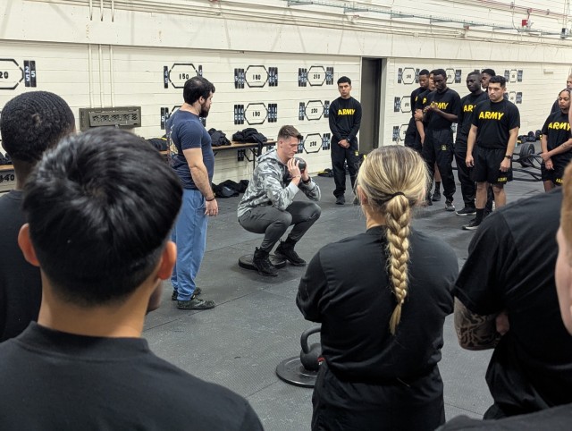 Sgt. John Dumetz, a noncommissioned officer with 2nd Battalion, 87th Infantry Regiment, 2nd Brigade Combat Team, demonstrates the proper movement for a goblet squat to a group of recently arrived Soldiers at Fort Drum. During in-processing,...