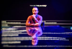 A man sits in front of a black background with the prompt 