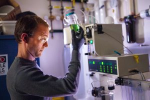 Brad Jones examines a mixture of ingredients that will be microencapsulated as part of a new technology developed by his team at Sandia National Laboratories with the goal of recycling materials from the inside out. (Photo by Craig Fritz) Click on the thumbnail for a high-resolution image.